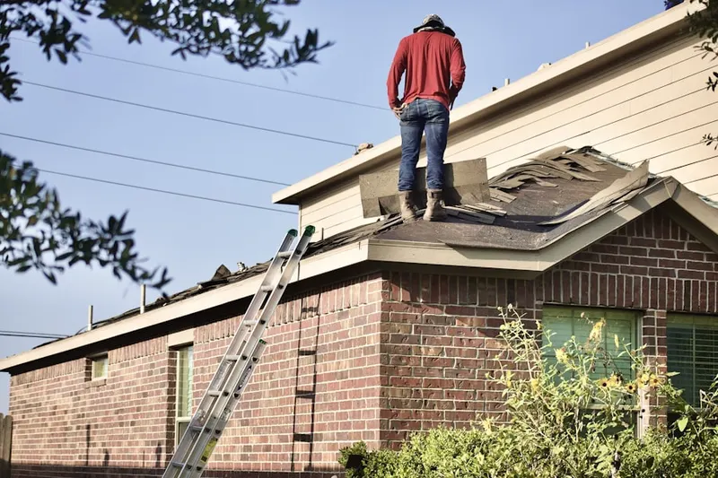 Professional roofer working on a residential roof in Hansen